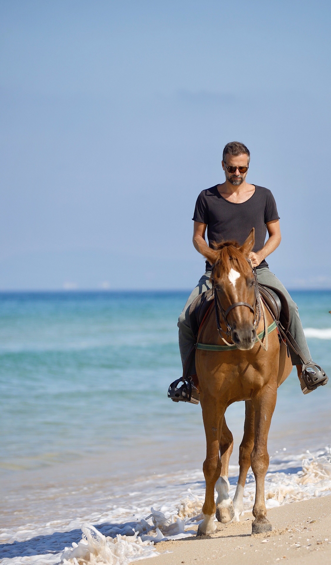 Horseback riding along ocean shoreline